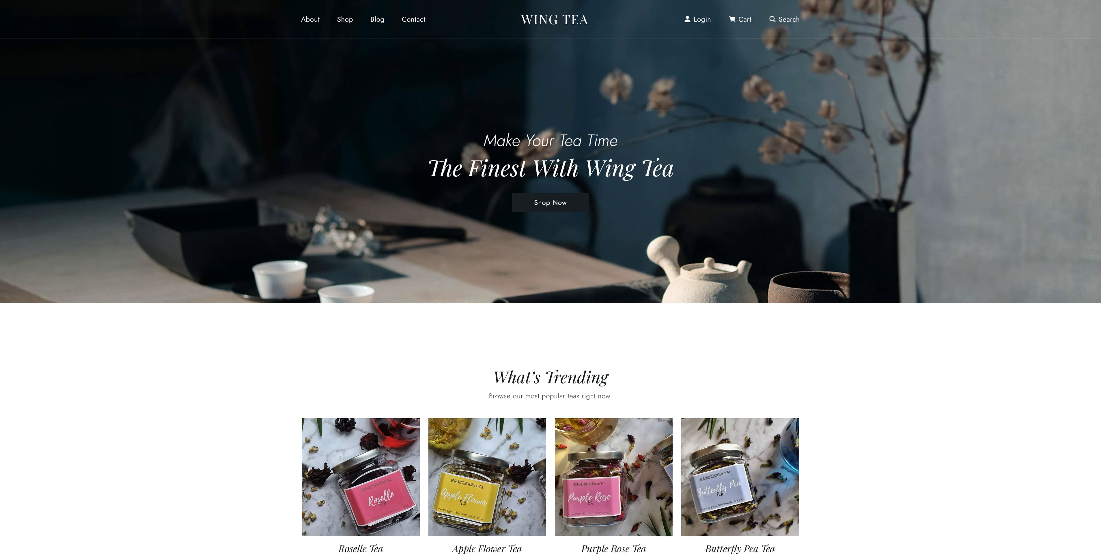 Website featuring a serene tea setup with a teapot and cups, dry twigs in the background, and a product gallery below showcasing colorful tea packages labeled Rose, Apple Flower, and Butterfly Pea.