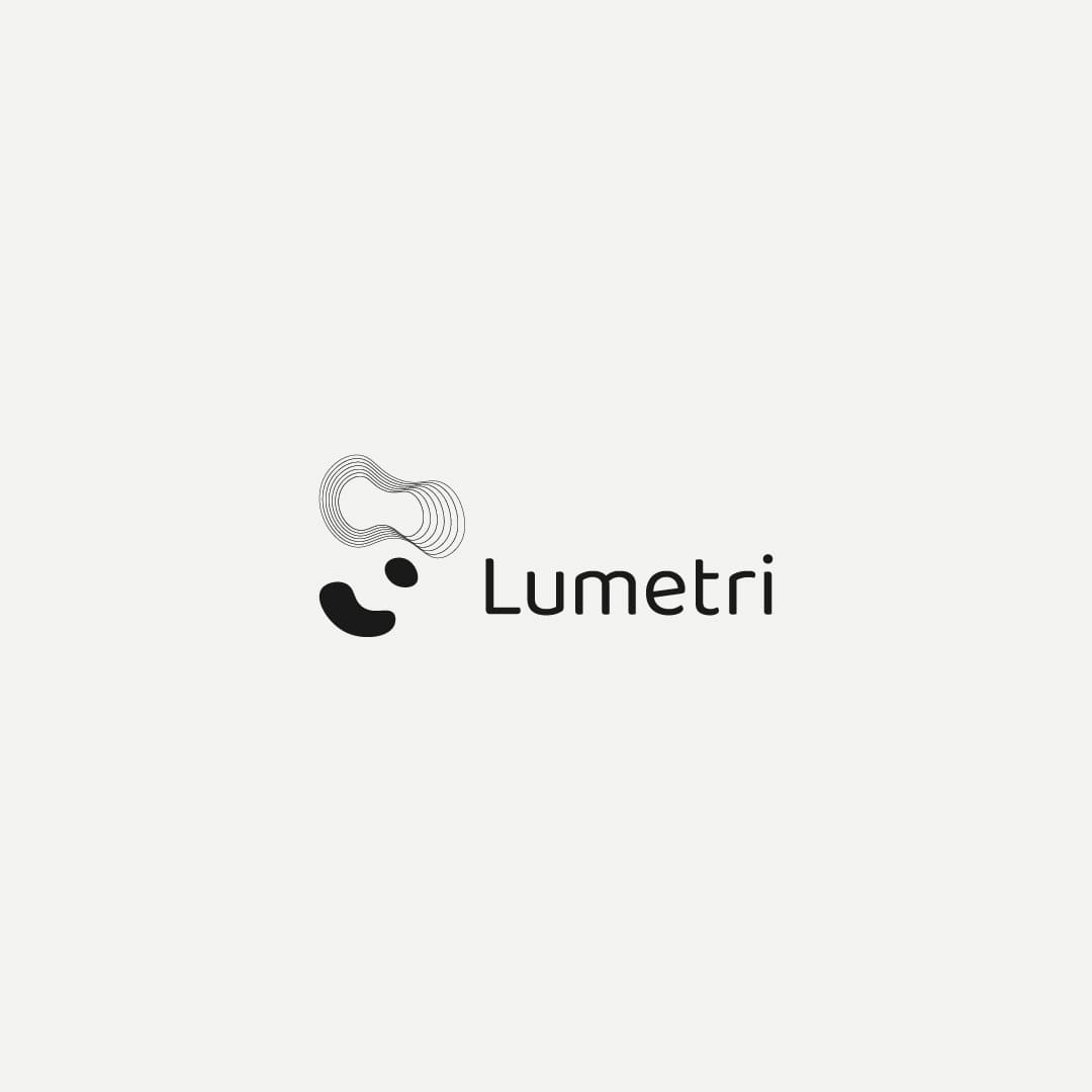 Black and white Lumetri logo with abstract shapes resembling abstract VR headset shape and a stylized face, conveying a modern and innovative tone.