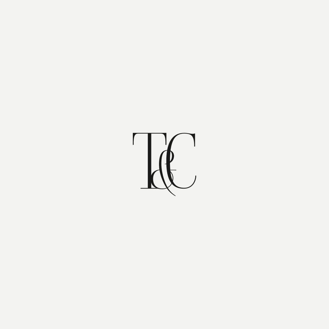 A monogram logo with stylized black serif letters T & C centered on a plain white background, conveying elegance and simplicity.